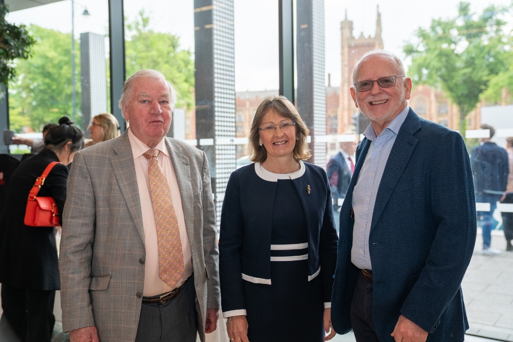 two men and a lady in smart clothing smiling to camera