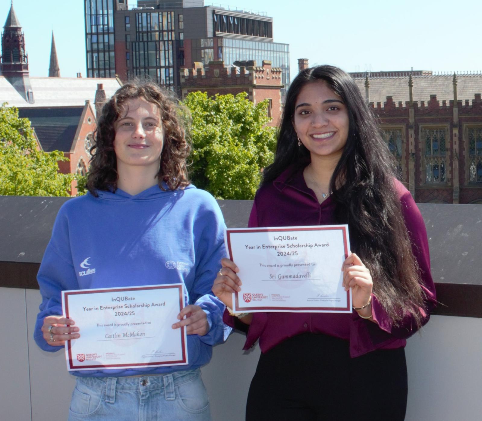 Two students holding InQUBate YIE scholarship award certificates