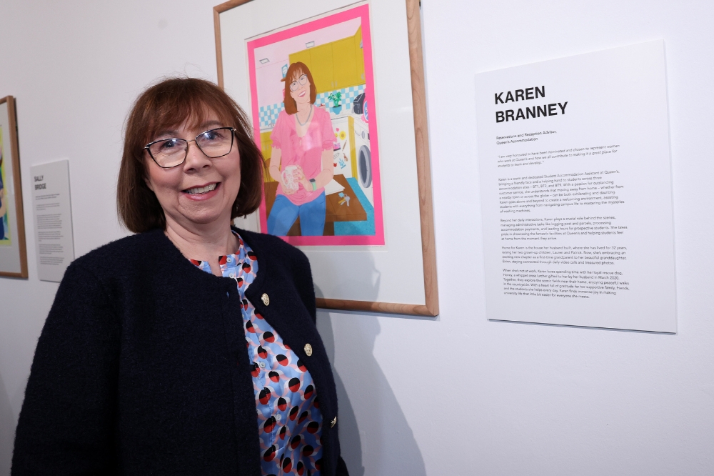 Nominee Karen Branney standing in front of her portrait in the Naughton Gallery