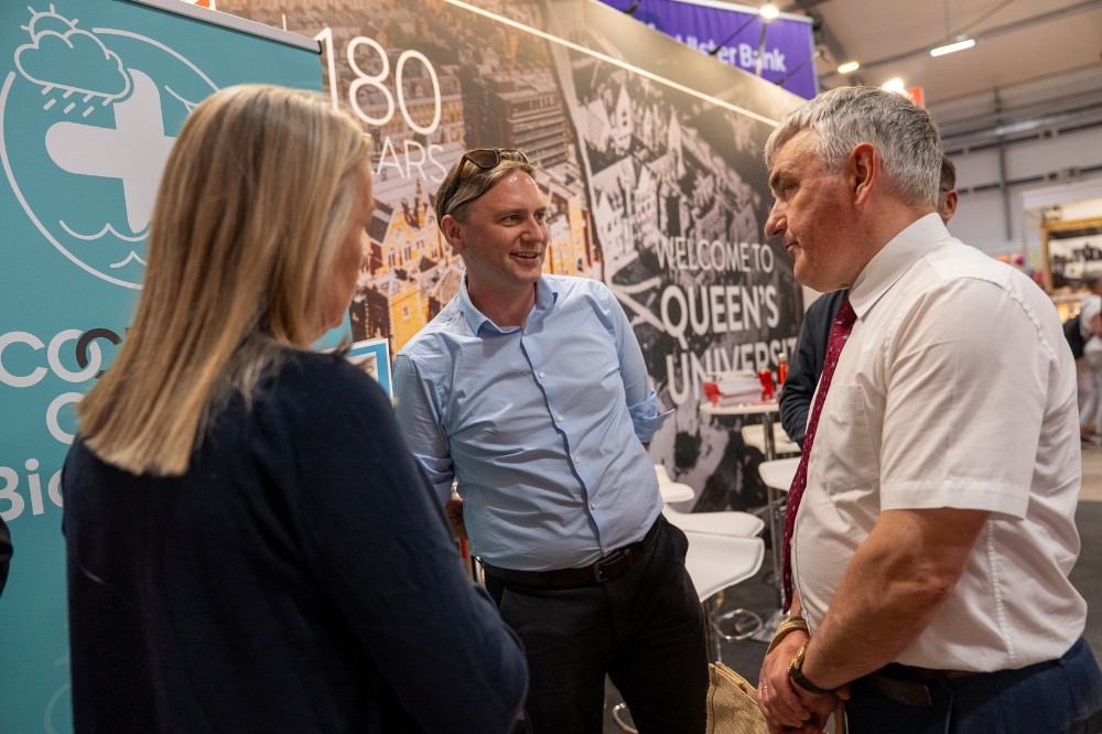 two men and a woman chatting at an indoor exhibition