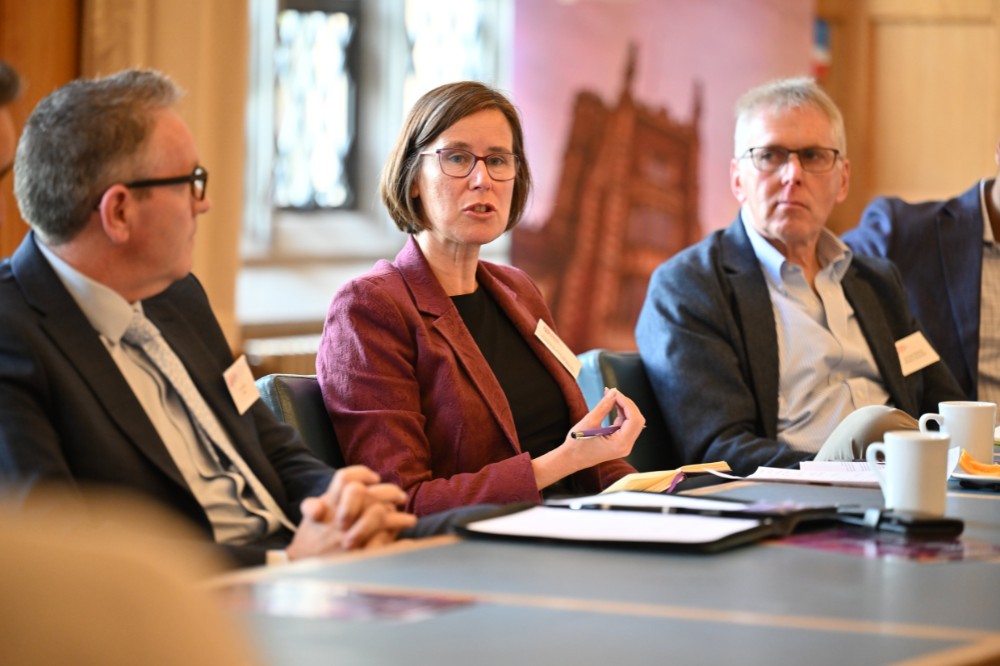 professional-looking female leader talking in a seated boardroom setting