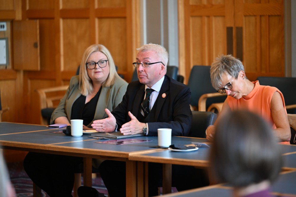 professional-looking male leader talking in a seated boardroom setting