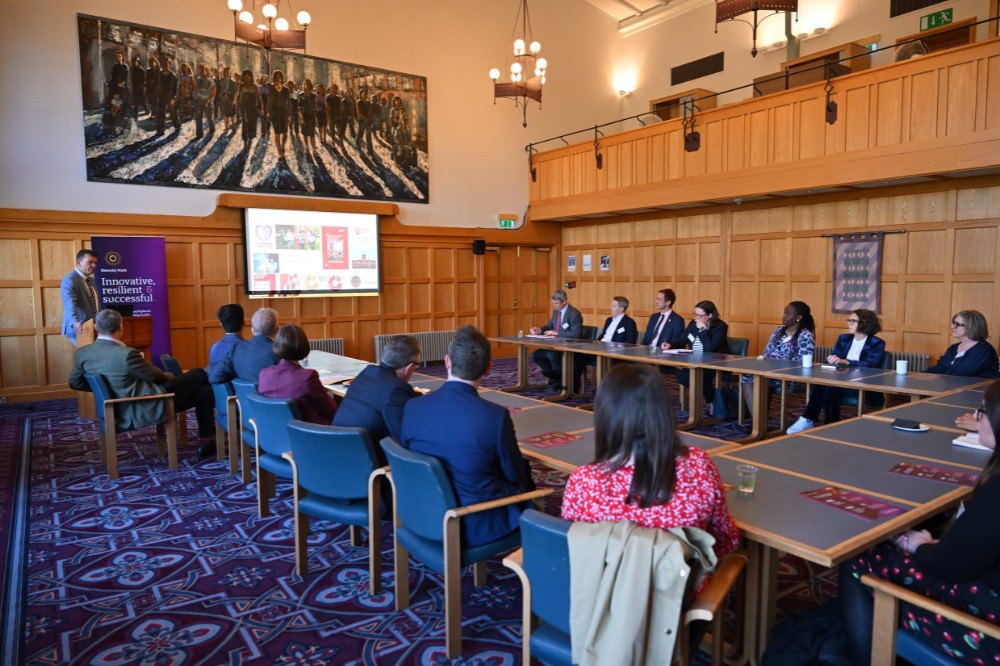 group of professionals seated in a plush boardroom setting listening to a talk