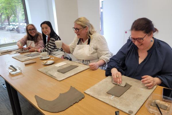 Staff members working on rectangular clay pieces