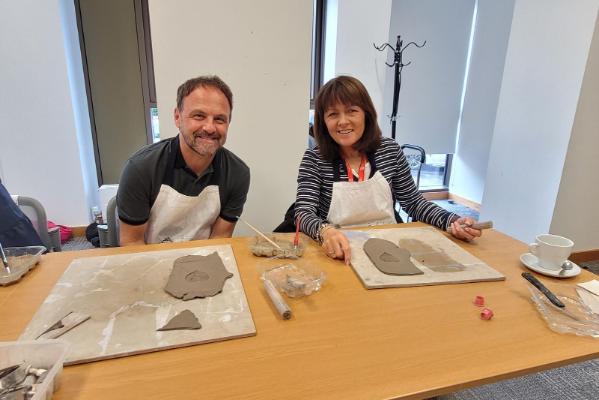 Staff sitting at a table creating clay creations