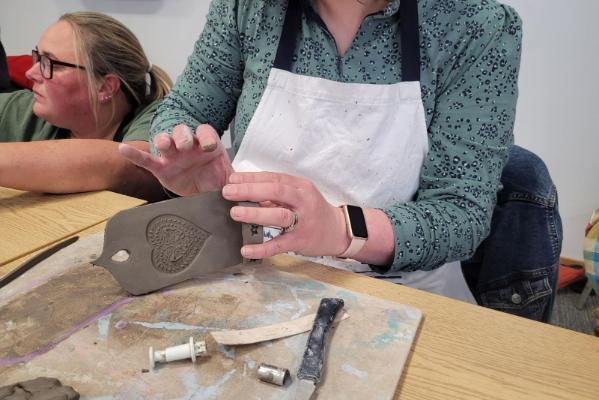 Staff member working on a clay wall candle sculpture
