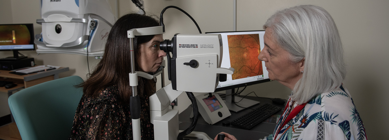 Female patient receiving eye scan from female doctor