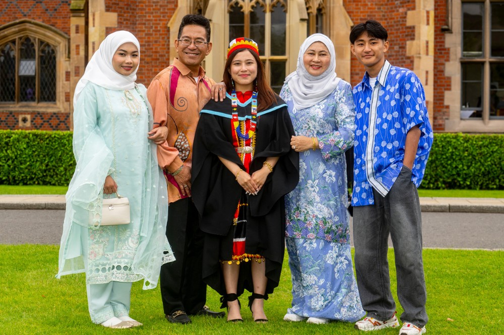 group of five people of Asian origin celebrating the graduation of the lady in the middle