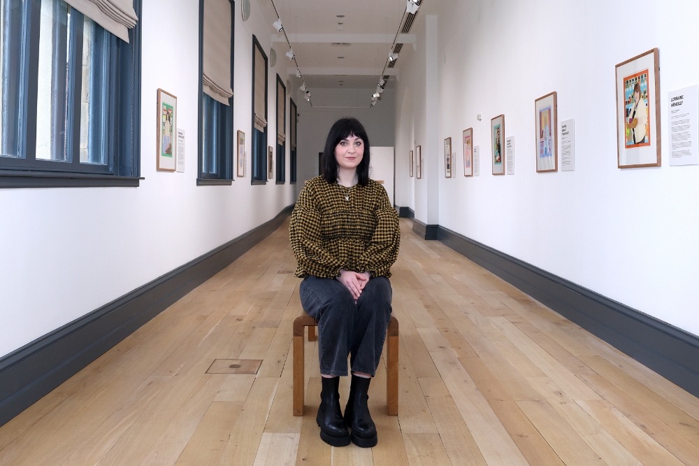 Irish Artist Laura Callaghan smiling and sitting on a bench to mark the launch of the Portrait Illustration Project.