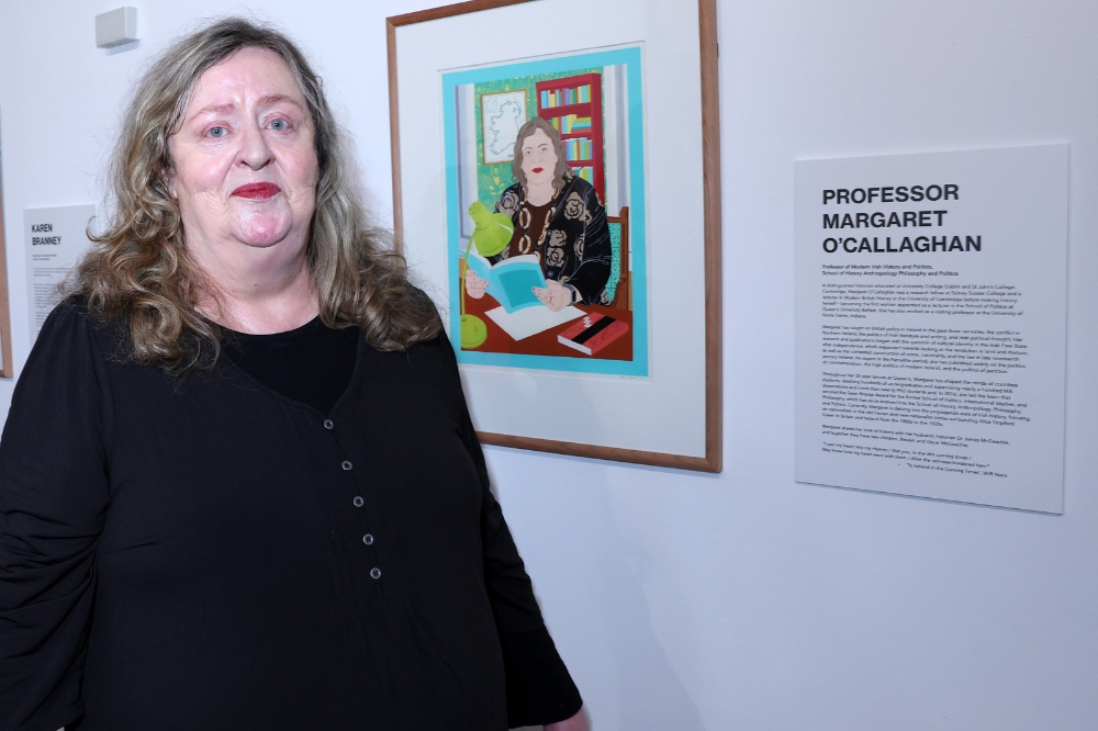 Nominee Margaret OCallaghan standing in front of her portrait in the Naughton Gallery