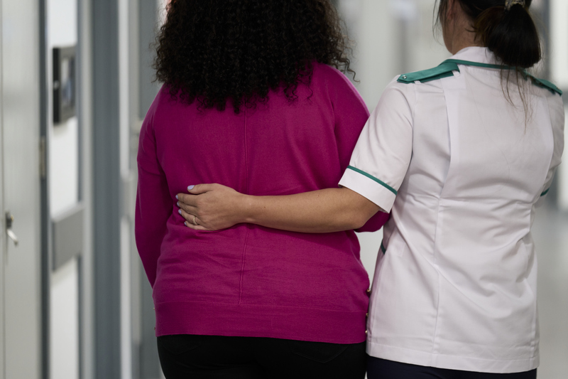 Nurse walking with arm around patient