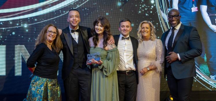 Three women and three men smiling and posing on stage at an awards ceremony. One of the women is holding a 'Property Week' trophy.