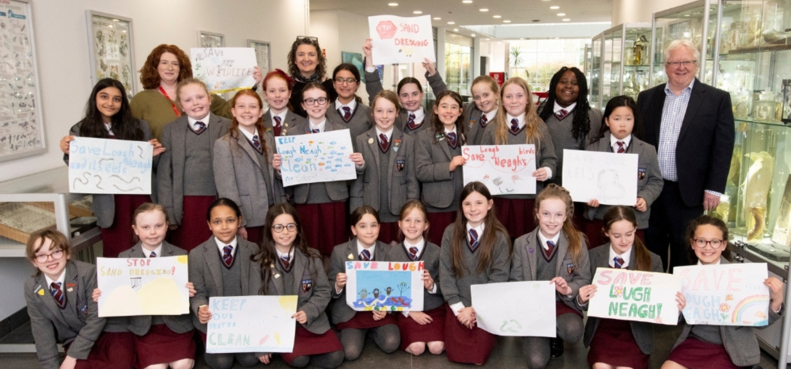 A smiling bunch of enthusiastic participants at the Reach'25 workshop proudly showcasing their artwork