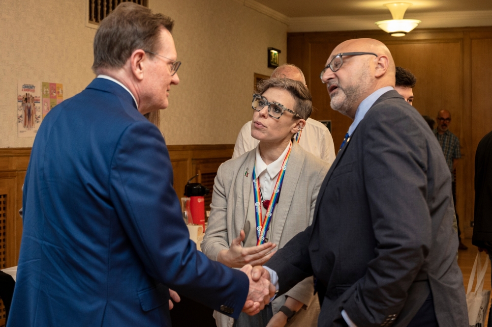 Sir Ian Greer, President and Vice-Chancellor of Queen’s University, shaking hands with an external guest at the 2025 Refugee Week event.