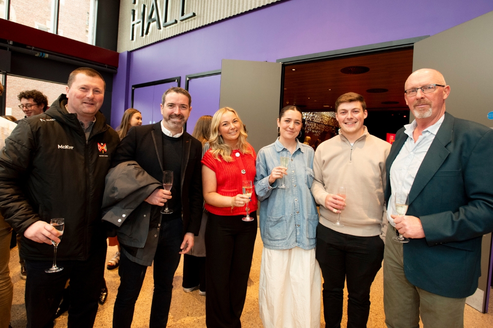 group of people smiling outside Mandela Hall, Queen's University Belfast