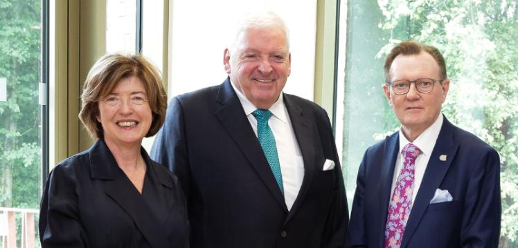 Baroness Gray, Dr McCormack, and Professor Sir Ian Greer stand side by side smiling at the camera