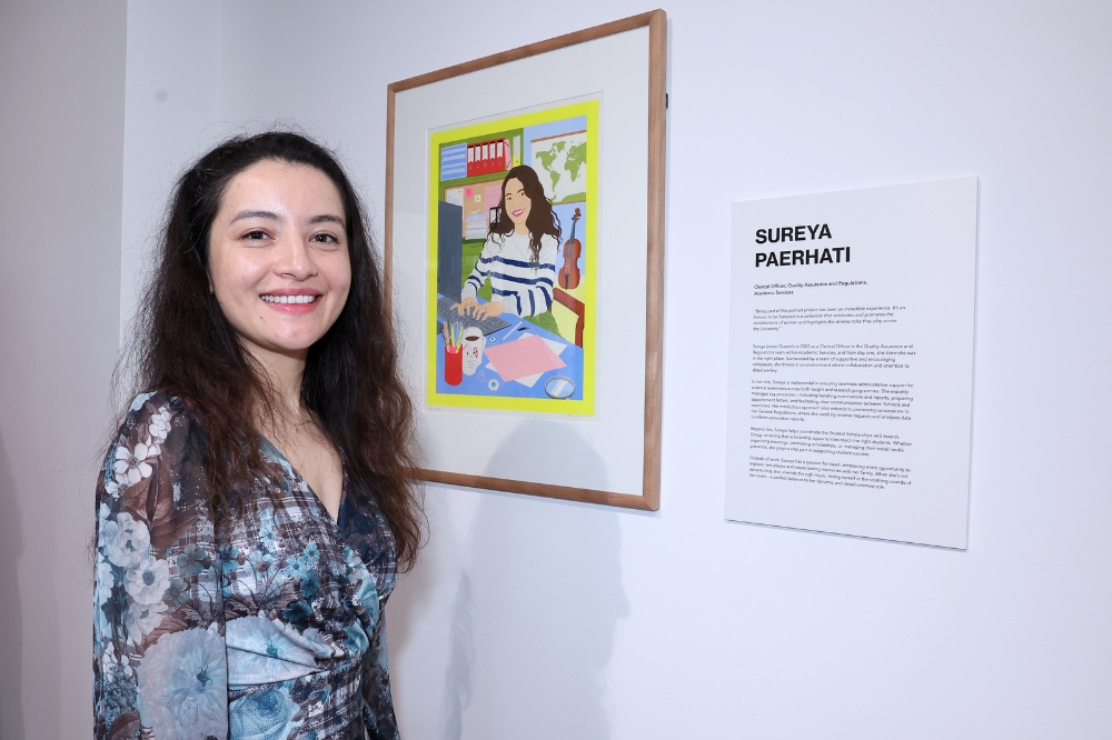 Nominee Sureya Paerhati standing in front of her portrait in the Naughton Gallery
