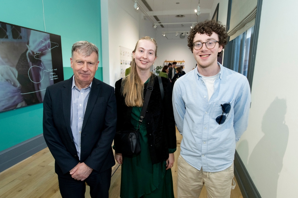 Three smiling participants posing for the launch of Reach'25