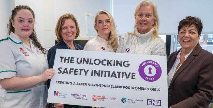 Women standing with a prop