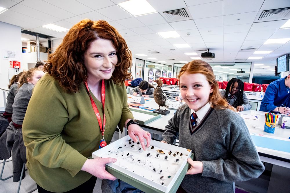 A smiling woman and child at the Reach'25 Workshop