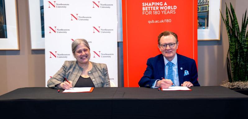 Image shows the Provost of Northeastern University and the Vice-Chancellor of Queen's signing an agreement.